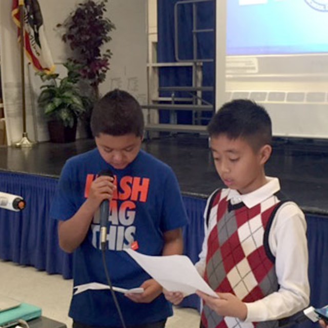 Three students learn public speaking skills while presenting for the class.